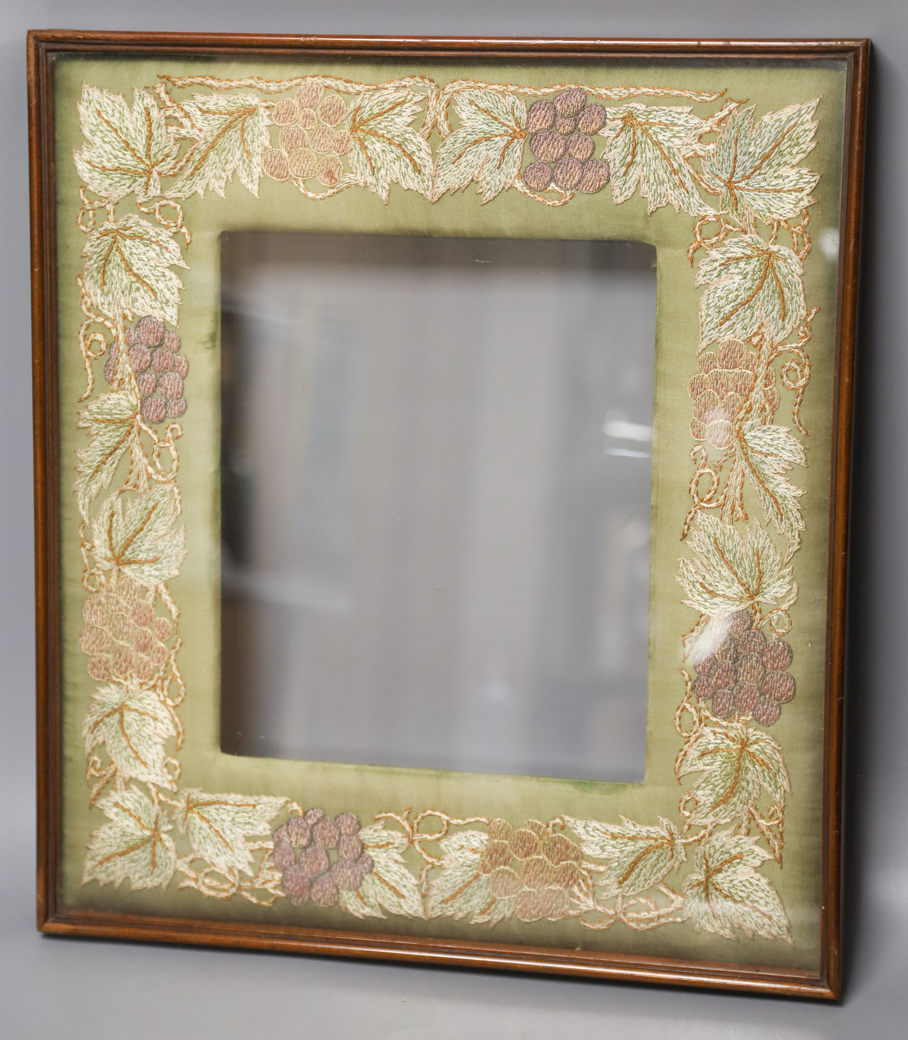 A mahogany picture frame with needlework mount 48x42cm